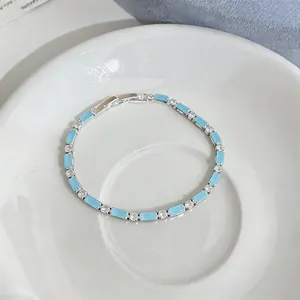 Primo piano di un bracciale in argento con smalto azzurro e zirconi scintillanti