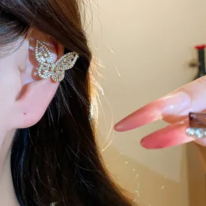 Detailed close-up of a sparkling butterfly ear cuff adorned with clear zircons on model ear