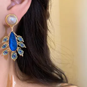 Detailed view of vintage blue enamel peacock feather teardrop earrings with pearl stud