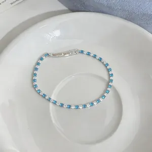 Dettaglio elegante del bracciale tennis con zirconi bianchi e blu alternati.