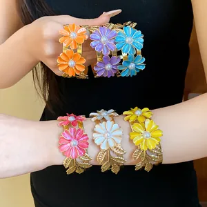 Detailed view of vibrant enamel flower cuff bracelets with pearls in multiple colors.