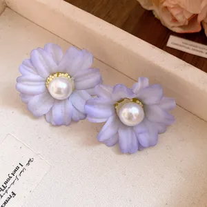 Close-up detail of romantic lavender fabric flower earrings with white pearl centers