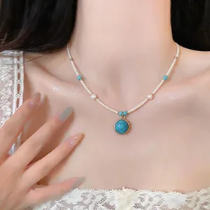 Elegante primo piano di una collana di perle d'acqua dolce con pendente turchese