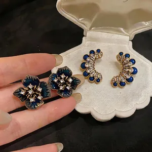 Vintage dark blue flower stud earrings with crystals in a white shell jewelry box