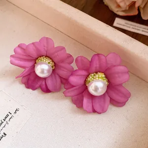 Detailed view of elegant retro pink fabric flower stud earrings with a central white pearl