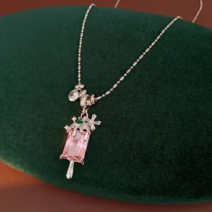 Exquisite pink zircon popsicle pendant necklace with floral accents on luxury green velvet
