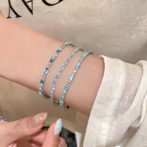 Vista dettagliata di bracciali in argento con pietre di zircone blu chiaro al polso