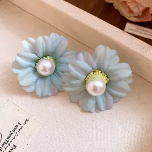 Detailed view of vintage fabric flower earrings with central pearl accents.