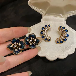 Detailed view of vintage dark blue flower and beaded earrings with rhinestones