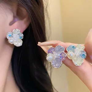Detailed macro shot of elegant floral stud earrings featuring pearls and colorful zircons