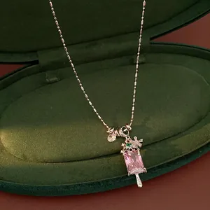 Detailed macro view of an ice cream shaped pendant with pink zircon and snowflake charm