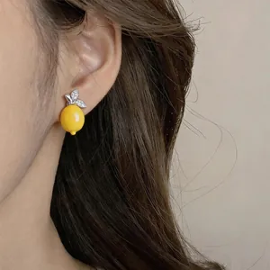 Close-up detail of a vintage lemon stud earring with yellow resin and sparkling zircons