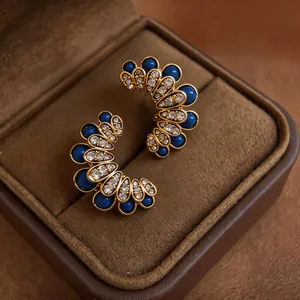 Elegant vintage flower stud earrings with deep blue gems and diamonds in jewelry box