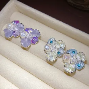 Macro view of dainty flower stud earrings with sparkling pearls and colorful zircons