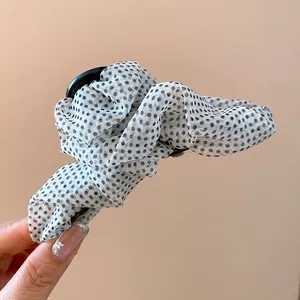 Detailansicht der eleganten Haarklammer mit gepunktetem Netzstoff und Falten-Design.