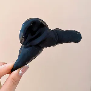Detailansicht einer schwarzen, plissierten Haarklammer aus Netzstoff für elegantes Styling