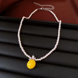 Elegant pearl necklace featuring a bright yellow lemon pendant with zircon leaves