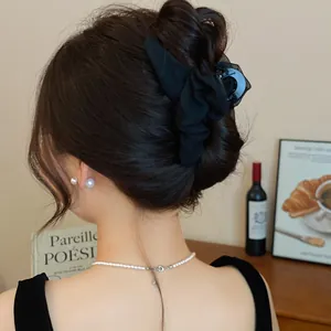 Rückansicht einer Frau mit einer eleganten schwarzen Haarklammer aus Mesh für einen Dutt.