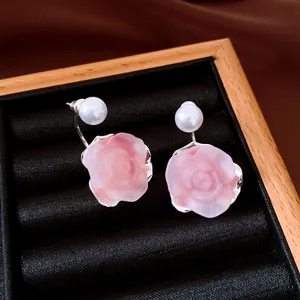 Detail view of French retro pink rose earrings with white pearls in a black velvet tray