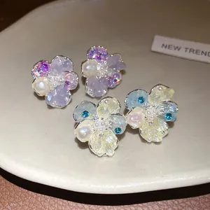 Detailed view of elegant flower-shaped stud earrings with pearls and crystal accents