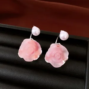 Detail of French vintage pink rose stud earrings with pearls in a black jewelry box
