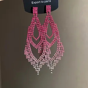 Nahaufnahme von funkelnden, abgestuften tropfenförmigen Ohrringen mit rosa Strass