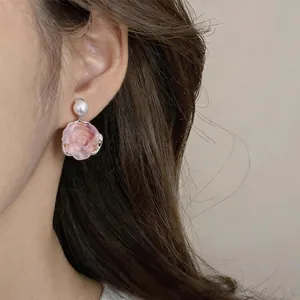 Detailed view of elegant pink flower resin earrings with a pearl stud for vintage style
