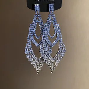 Detailansicht von eleganten silbernen Tropfenohrringen mit funkelnden blauen Strasssteinen