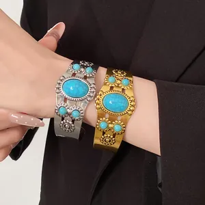Detail view of vintage oval flower open cuff bracelets with turquoise stones on wrist