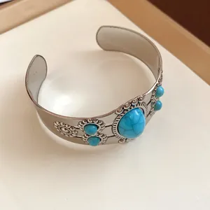 Vintage silver-tone cuff bracelet featuring oval turquoise stones and intricate floral carvings