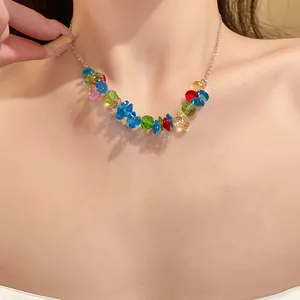 Vista dettagliata di una collana con perle di cristallo colorate irregolari su una catena.