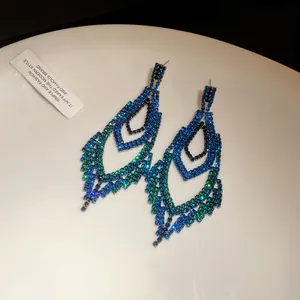Detailansicht von Luxus-Ohrringen mit blau-grünen Farbverlauf-Strasssteinen.