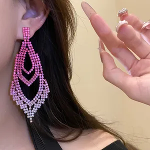 Nahaufnahme von rosafarbenen Strass-Ohrhängern mit Farbverlauf an einem Modell