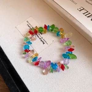 Primo piano di perline di cristallo colorate su un elegante bracciale irregolare.