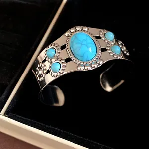 Close-up of vintage silver cuff bracelet featuring oval blue turquoise flower design