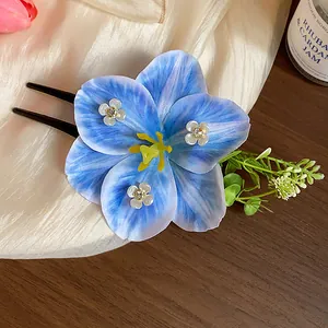 Detailed view of a blue fabric flower hair fork with sparkling rhinestone accents
