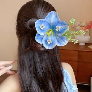 Elegant detail view of a blue fabric flower hair pin with sparkling rhinestones on hair