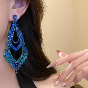 Detaillierte Makroansicht eleganter blauer Strass-Ohrhänger, getragen von einem Modell