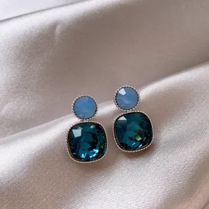 Close-up of vintage-style teal and light blue square crystal drop earrings