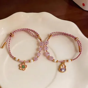 Hand-woven pink rope bracelet set featuring translucent beads, pearls and elegant floral charms