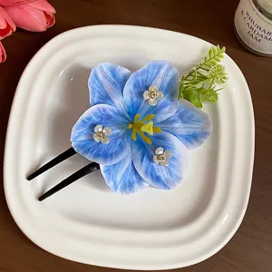 Close-up of elegant blue fabric flower hair fork with rhinestone details.