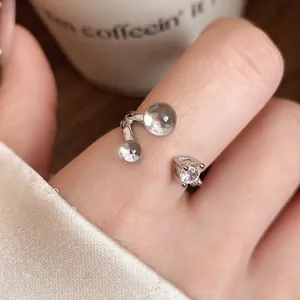 Bague ouverte élégante en argent avec zircon triangulaire et perles claires sur doigt