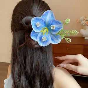 Close-up of a elegant blue fabric flower hair pin with rhinestone accents