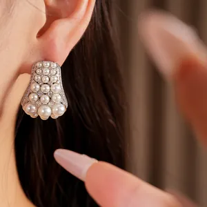 Close-up of elegant silver earrings featuring clusters of white pearls and zircons.