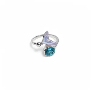 Bague ouverte élégante en argent avec queue de sirène irisée et zircon bleu sur fond blanc.