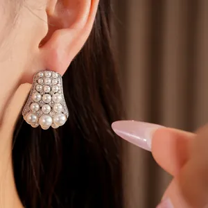 Close-up of elegant court style earrings featuring white pearls and sparkling zircons