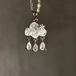 Macro detail of a cloud-shaped pendant necklace with sparkling teardrop zircons