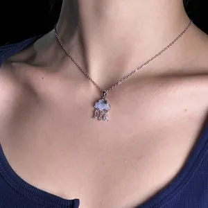 Detailed macro view of a silver cloud pendant necklace featuring light blue zircon rain drops