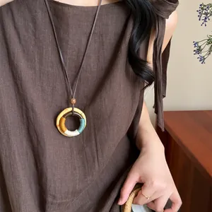 Bohemian long cord necklace featuring a handmade wooden ring pendant with colorful silk thread wrap