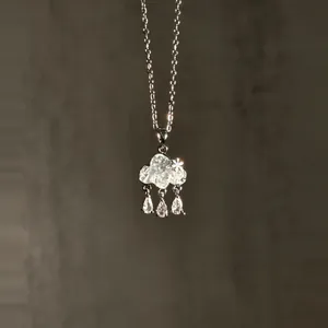 Detailed macro shot of light blue cloud-shaped zircon necklace with raindrop charms